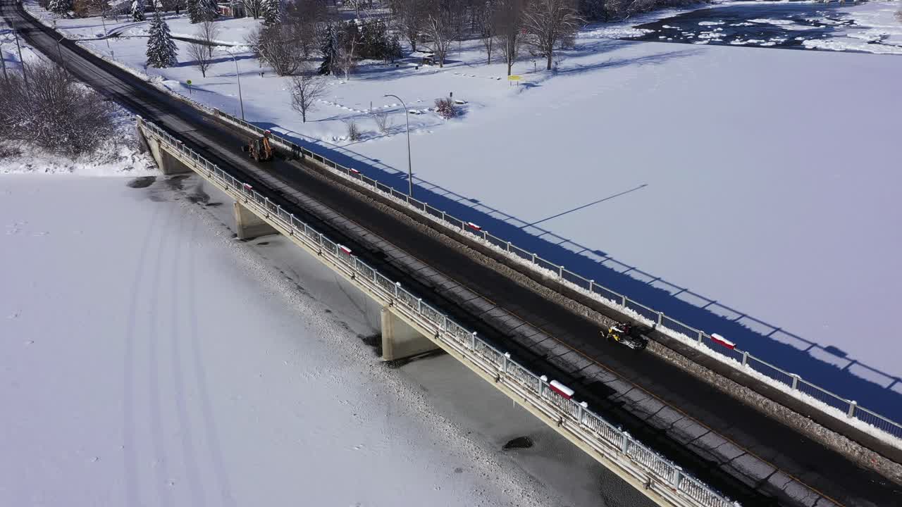 스노모빌은 공중 교량을 건너기 위해 도로를 주행해야 합니다.