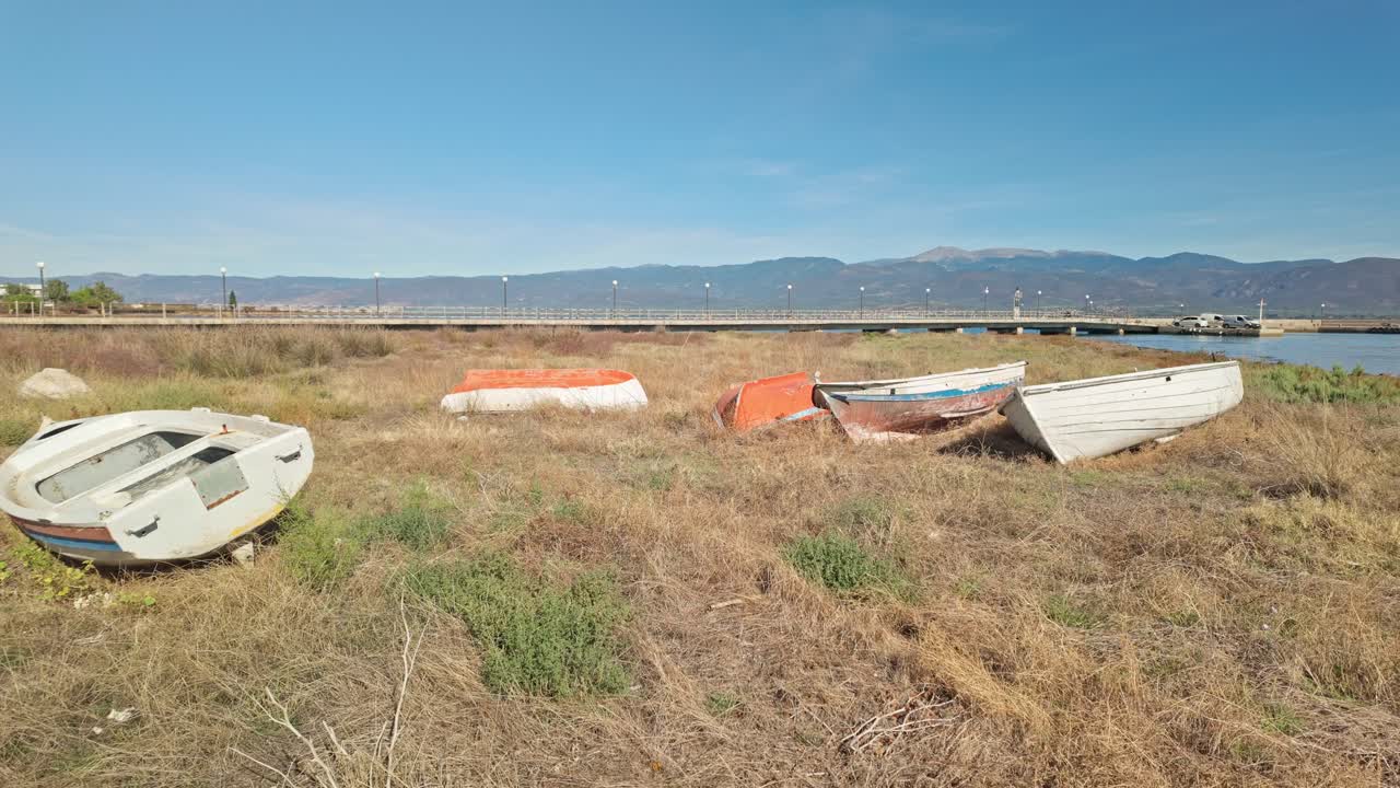 Derelict Greek wooden fishing boats neglected on grassy beach