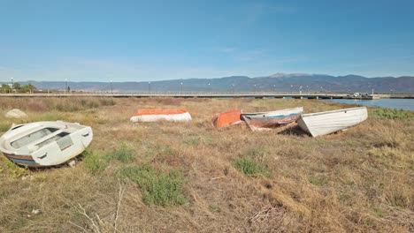 derelict greek wooden fishing boats neglected on grassy beach