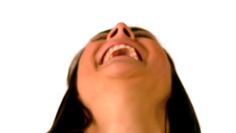 una morena feliz riendo sobre un fondo blanco