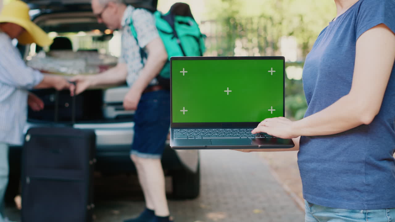 People with luggage using laptop on vacation