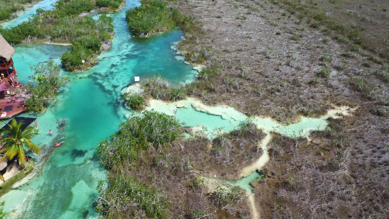 vista aérea acercándose a la gente disfrutando de un día cálido en los rápidos de bacalar, en el soleado méxico