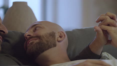 gay couple lying in bed in morning and looking at each other