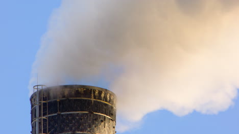 harmful greenhouse gases from factory chimney polluting the air, telephoto