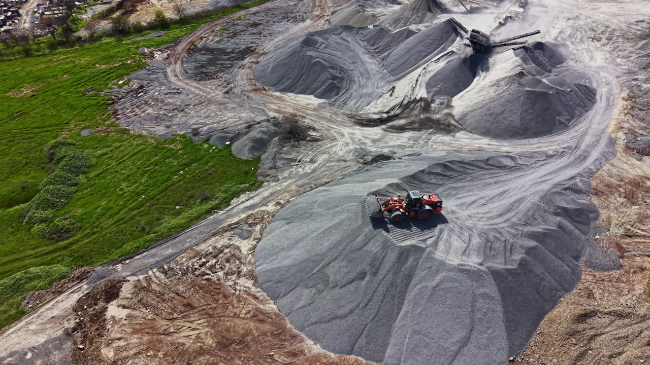 Workers focus on granite quarry operations during daylight, moving materials and shaping the landscape at a busy construction site