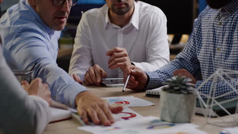 close-up view of caucasian business team analyzing documents, charts, financial reports and graphics in the office