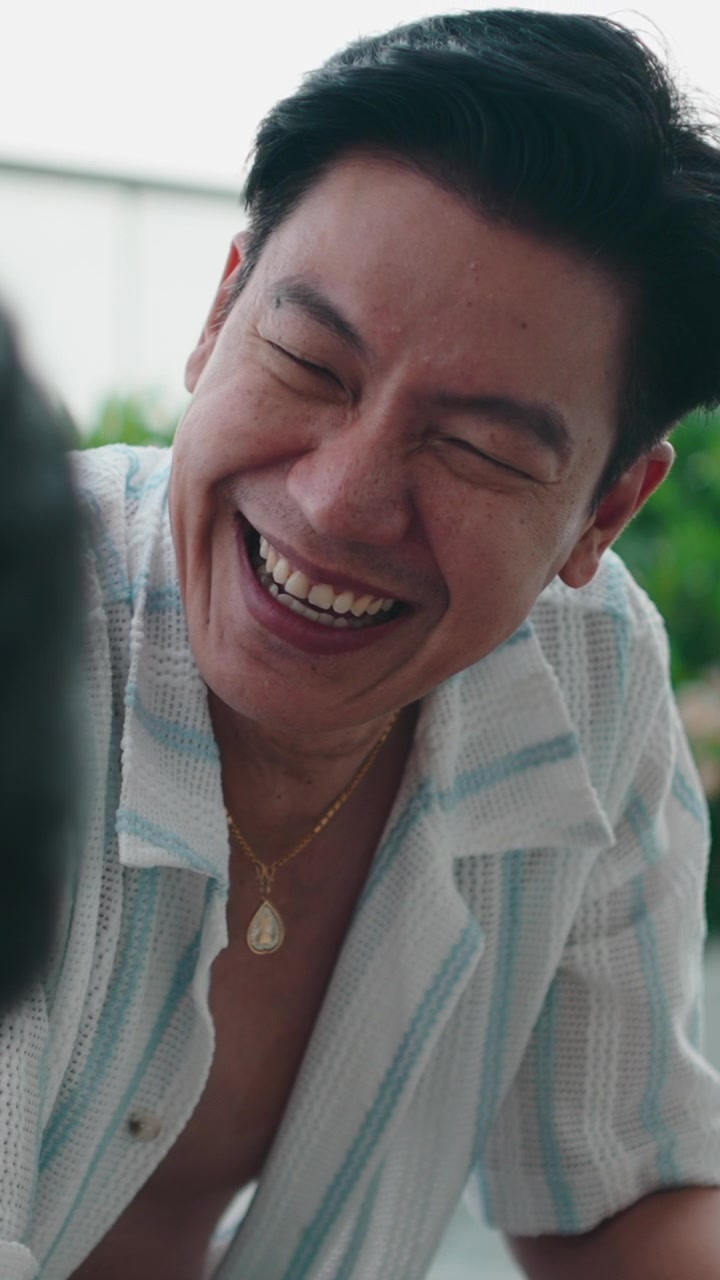 Happy Asian Man Laughing During Casual Conversation