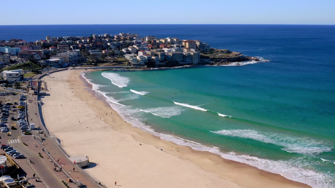 Onde calme sulla riva con auto parcheggiate vicino al lungomare sabbioso della spiaggia di Bondi a Sydney, Nuovo Galles del Sud, Australia.