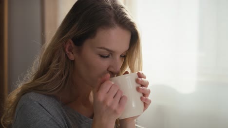 Mujer-Caucásica-Bebiendo-Café-Caliente-Por-La-Mañana-En-El-Interior-De-Una-Casa.
