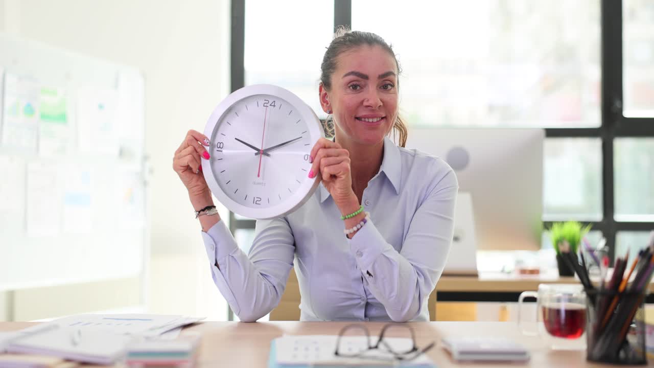Woman Holding Clock in Office