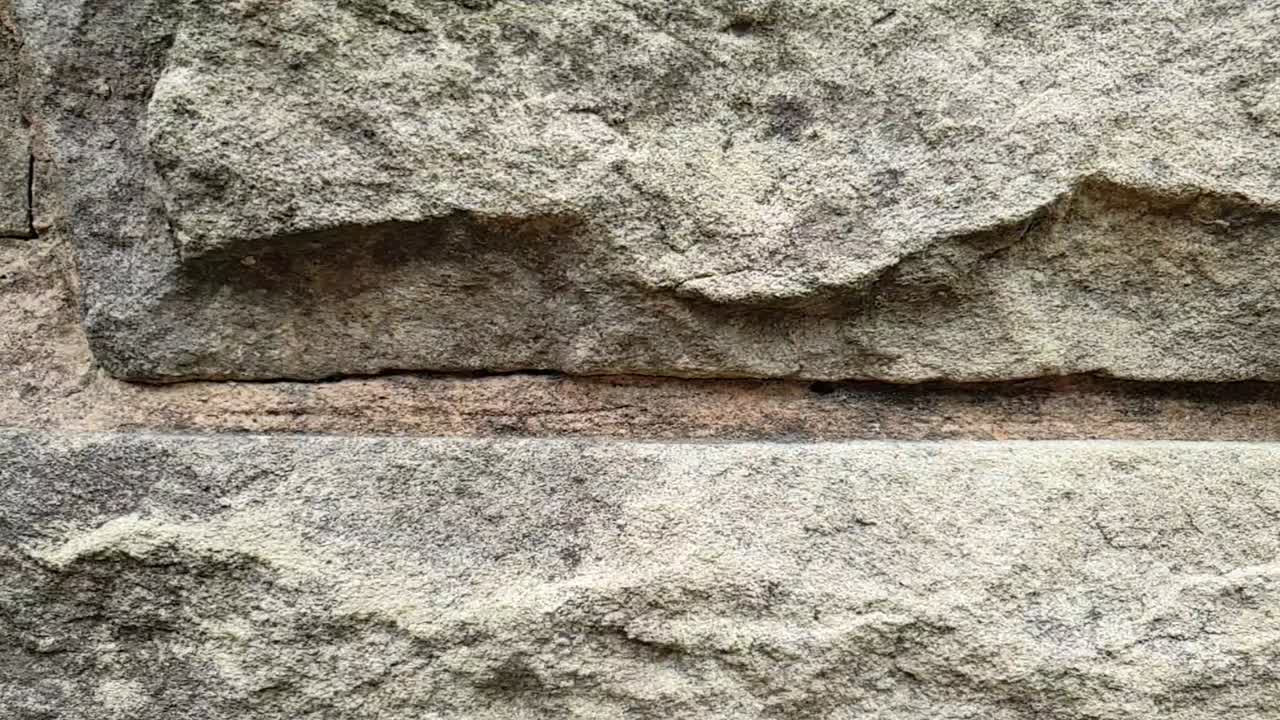 Brown Sandstone bricks slow motion slide on side of barbecue fireplace chimney, natural stone texture and patterns