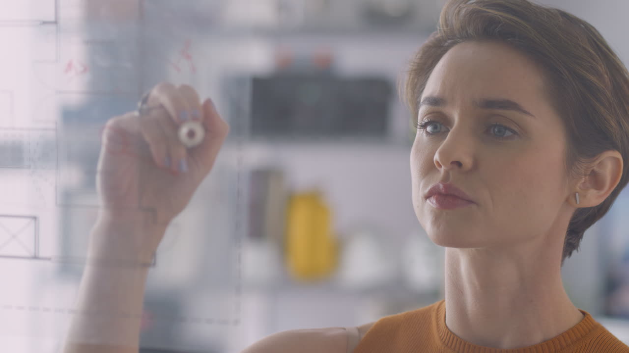 arquitecta femenina en la oficina haciendo notas sobre el plano del edificio en una pantalla transparente