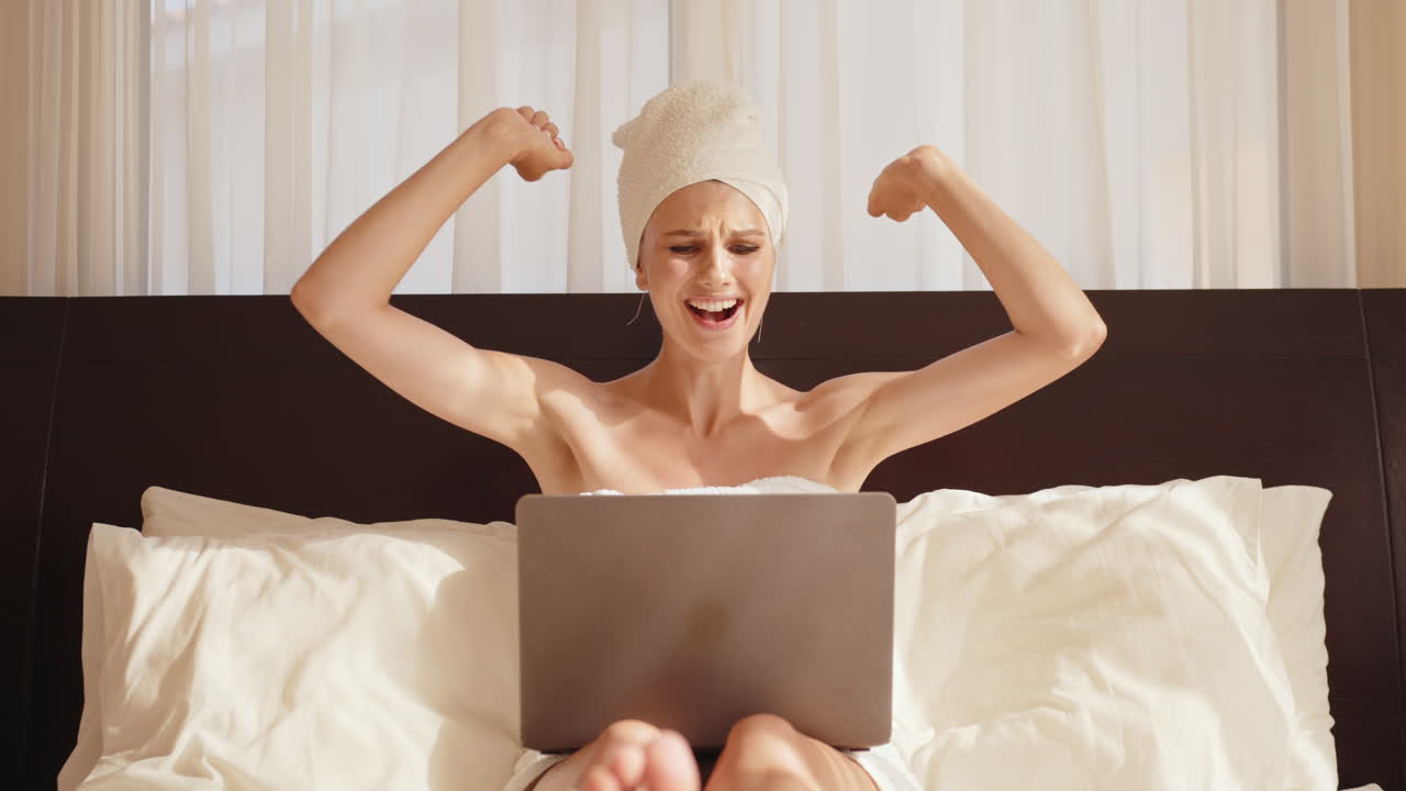 침대에 노트북으로 일하는 여자