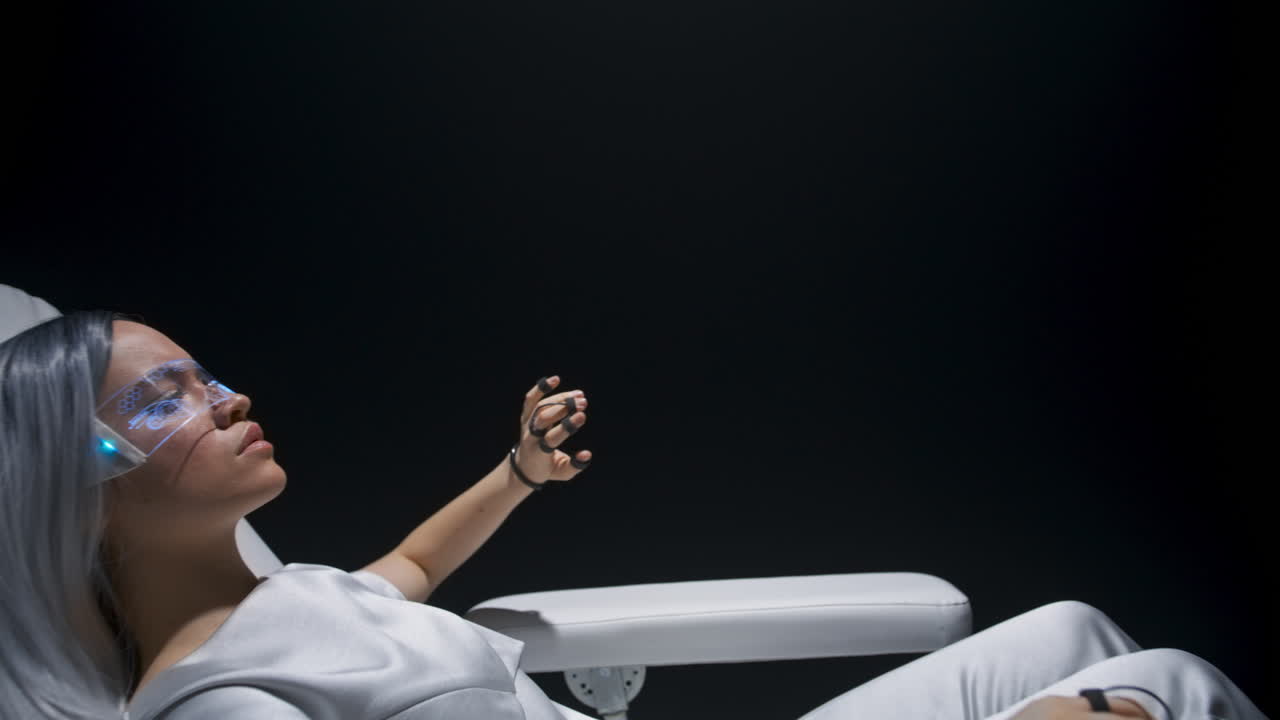 mujer con experiencia en vr. niña usando guantes de sensor sentada en un sillón.