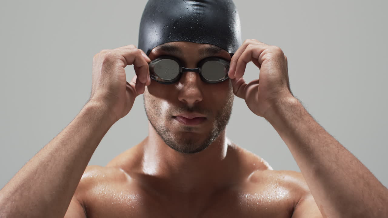 Focused swimmer adjusting goggles before a race