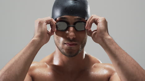 focused swimmer adjusting goggles before a race