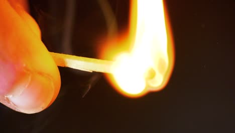 hd super slow motion cinematic macro shot of a match being lit, in a dark room