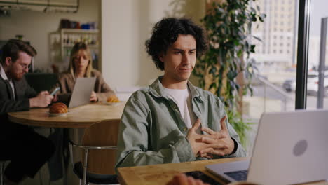 man working on laptop in a cafe