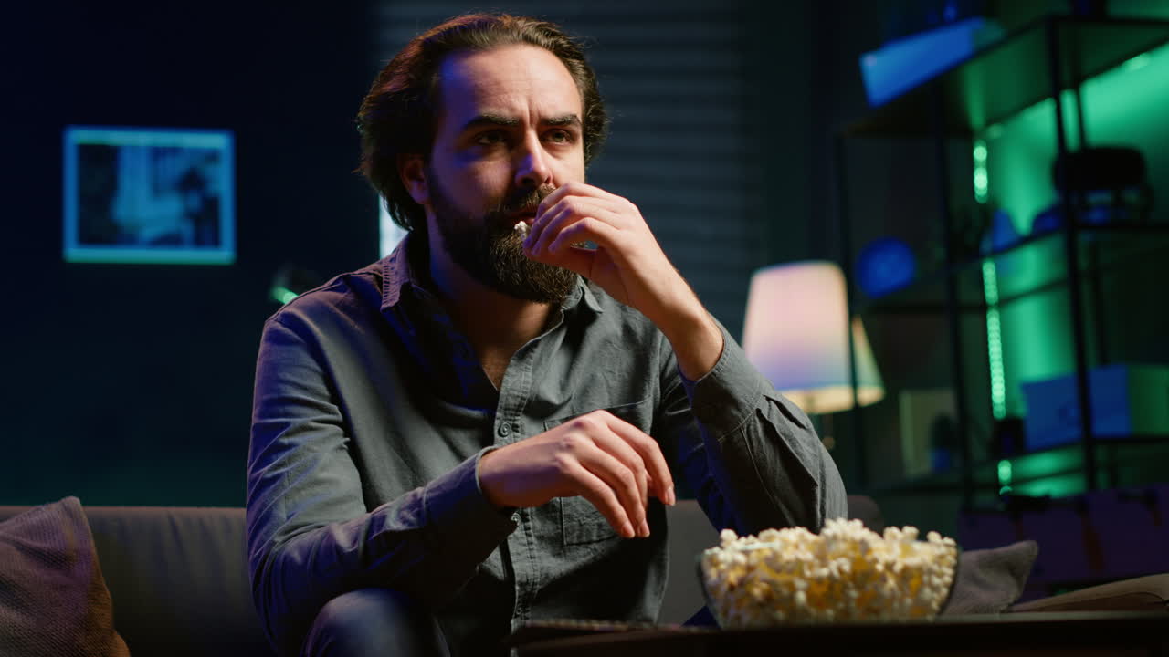 una persona perezosa que mira programas de televisión sin pensar y come palomitas de maíz