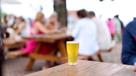 people socializing around a table with a beer