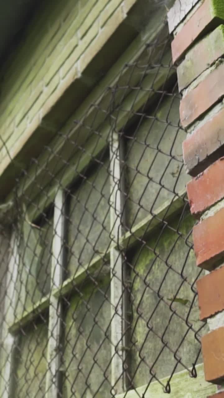 exterior de edificio antiguo con ventanas y valla desgastadas