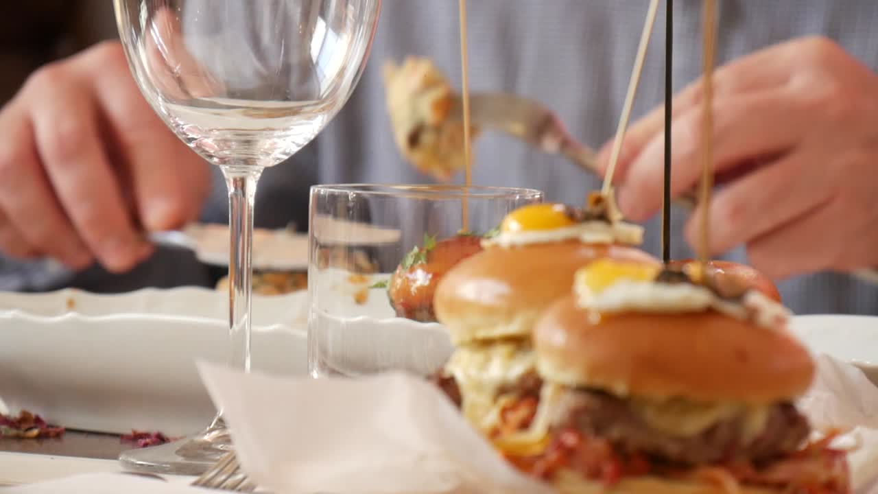 Close-up of gourmet burgers on a restaurant table as patrons eat their meal