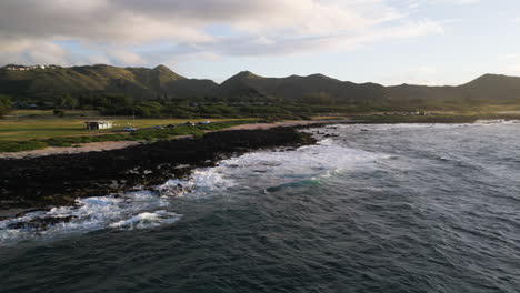 a drone pans and rotates during golden hour at sandy beach in oahu, hawaii