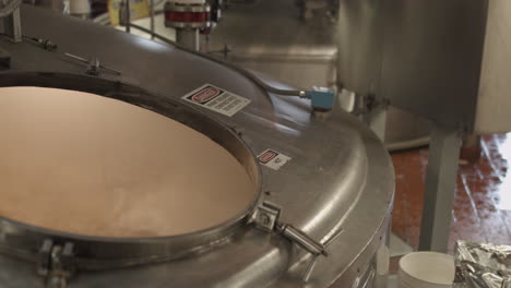 inside a brewery: close up of stainless steel fermentation tank