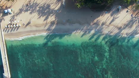 Vista-Aérea-De-Arriba-Hacia-Abajo-Del-Exótico-Agua-Turquesa-De-Waikiki-Con-Olas-Salpicando