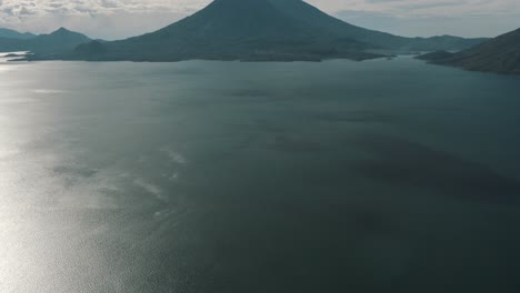 drone aerial revealing shot of the blue water of lake atitlan and san pedro volcano in guatemala