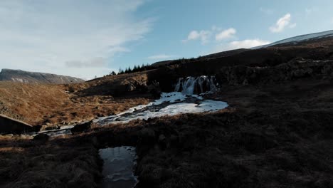 freezing river water from a small waterfall in iceland - drone