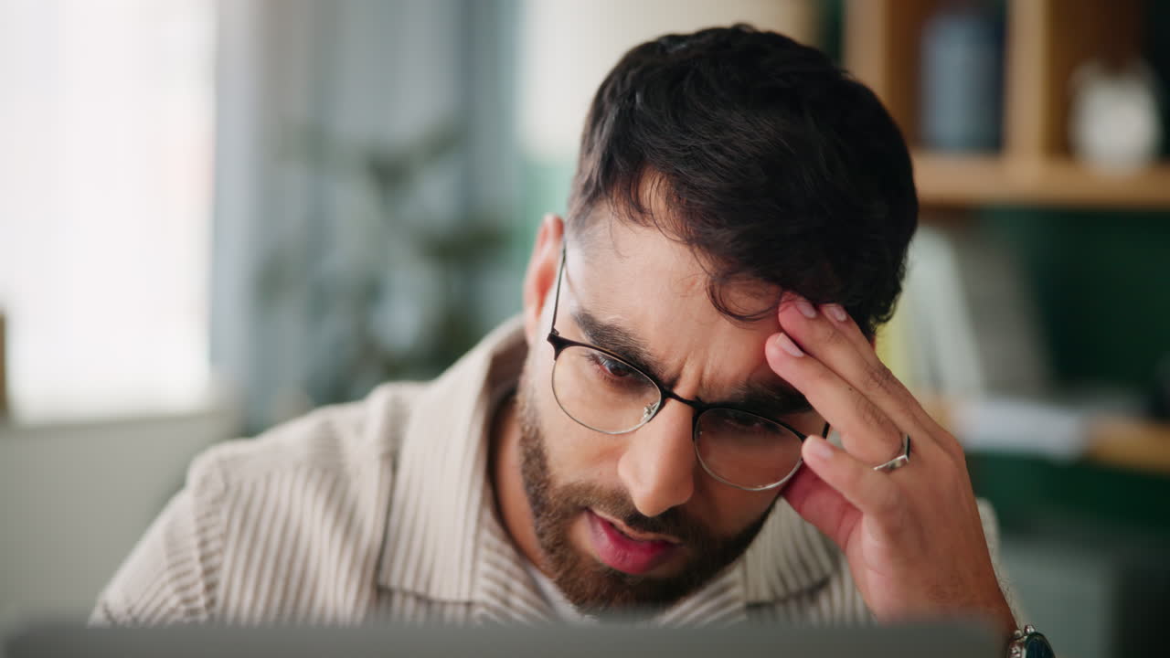 Stressed man with headache working on computer