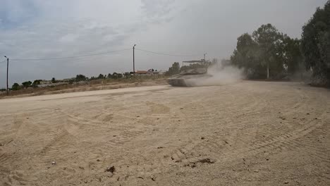 an israeli merkava tank in gaza creating a dust cloud as advances through desert