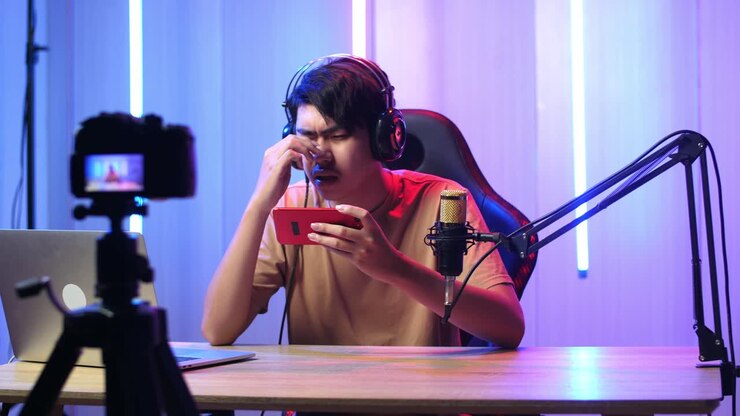 Uomo asiatico che gioca a un videogioco con il telefono cellulare, poi perde la partita durante una diretta streaming con la telecamera.