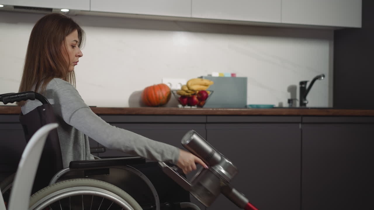 una joven seria se sienta en silla de ruedas cerca de la mesa de limpieza