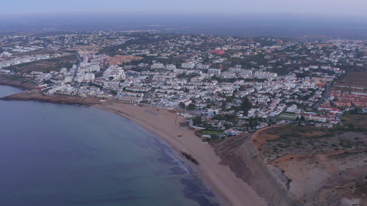 Aerial wide shot of Praia da Luz village on foggy day, Lagos. Algarve