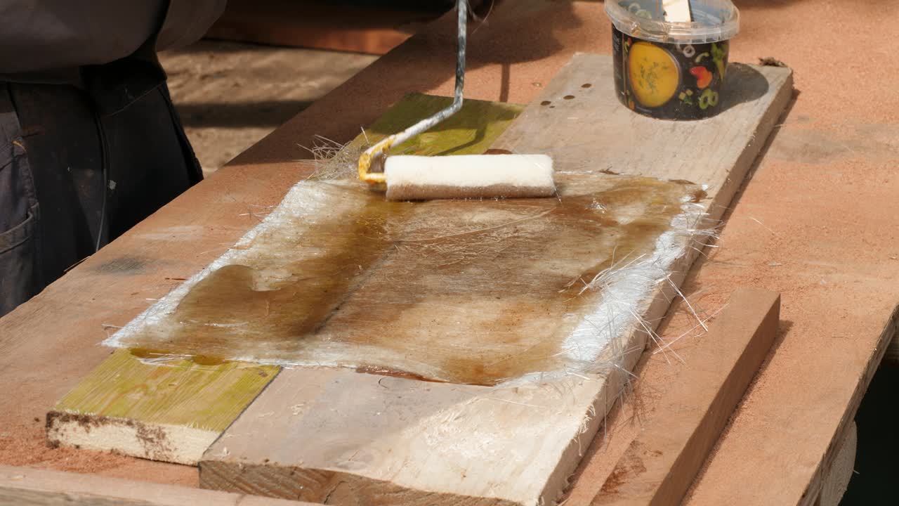Applying polyester resin to fiberglass CSM mat