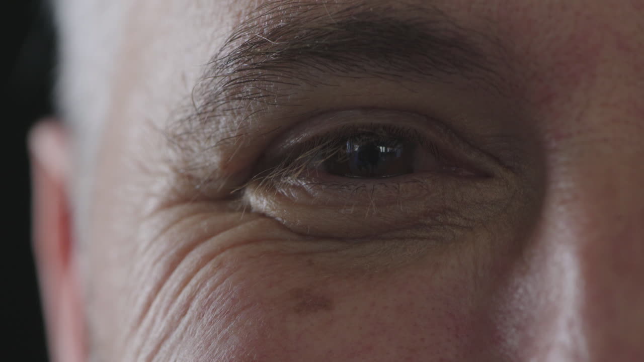 cerca del ojo masculino mirando a la cámara sonriendo feliz