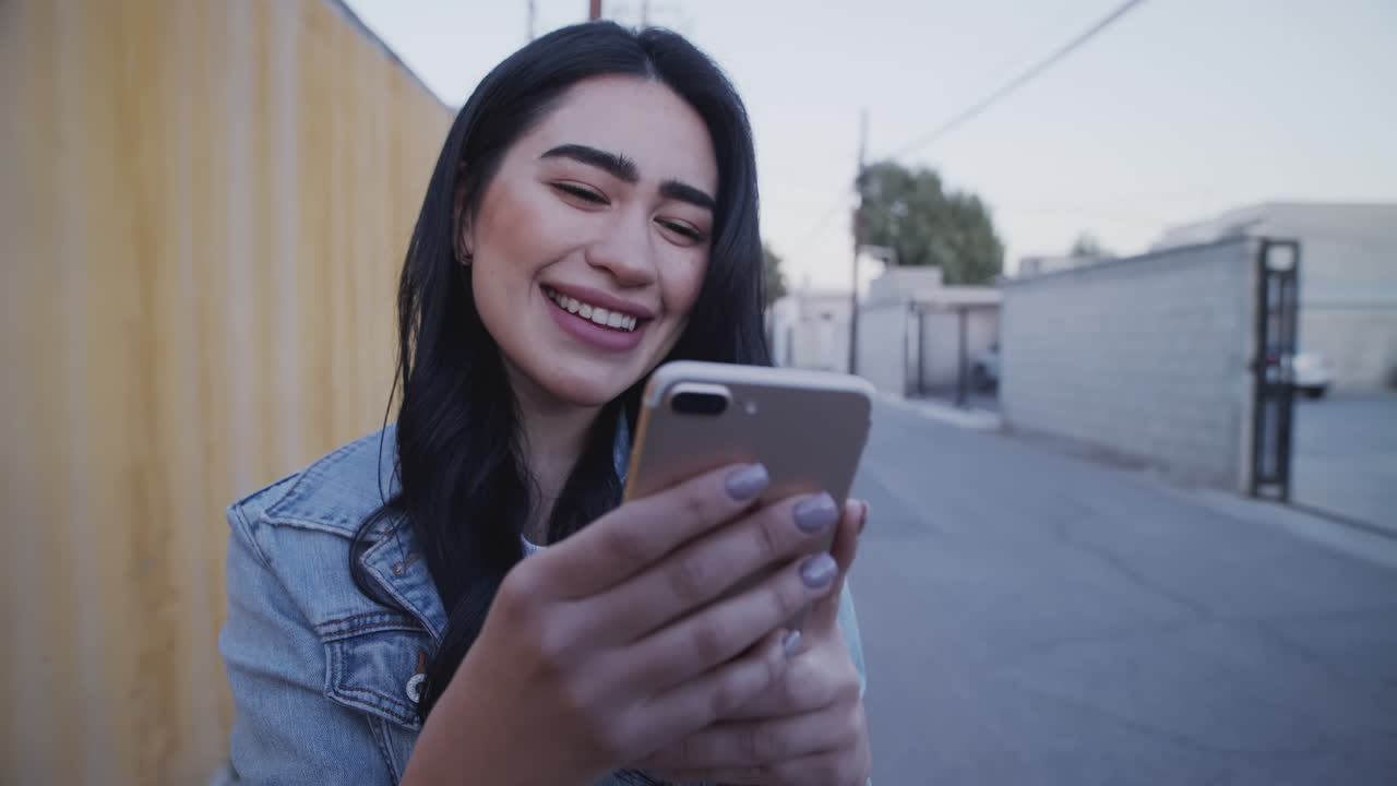 niña sonriente revisando su teléfono