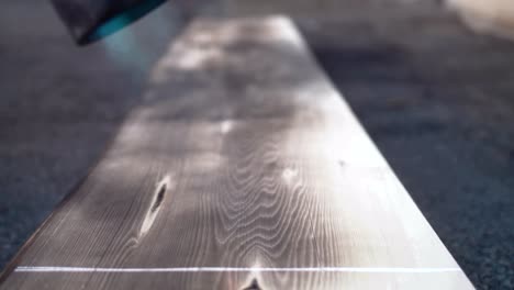 woodworker chars cedar plank with torch as part of wood finish