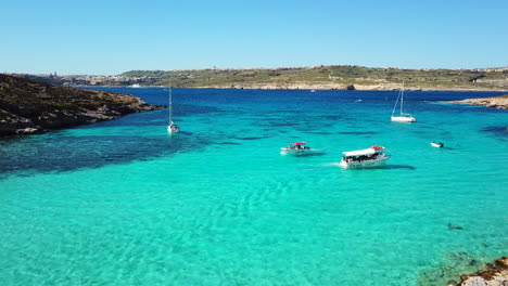 turquoise blue lagoon with boats and swimmers