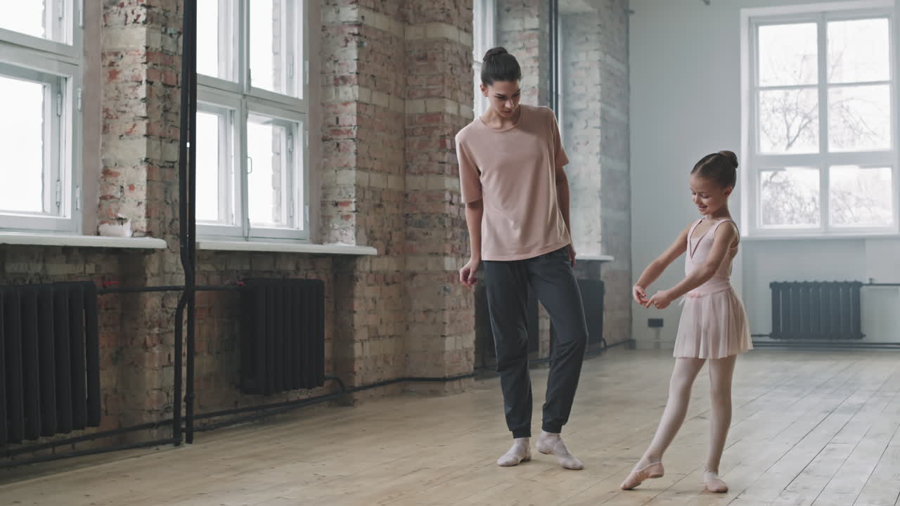Liten ballerina som lærer ballettposisjon med trener