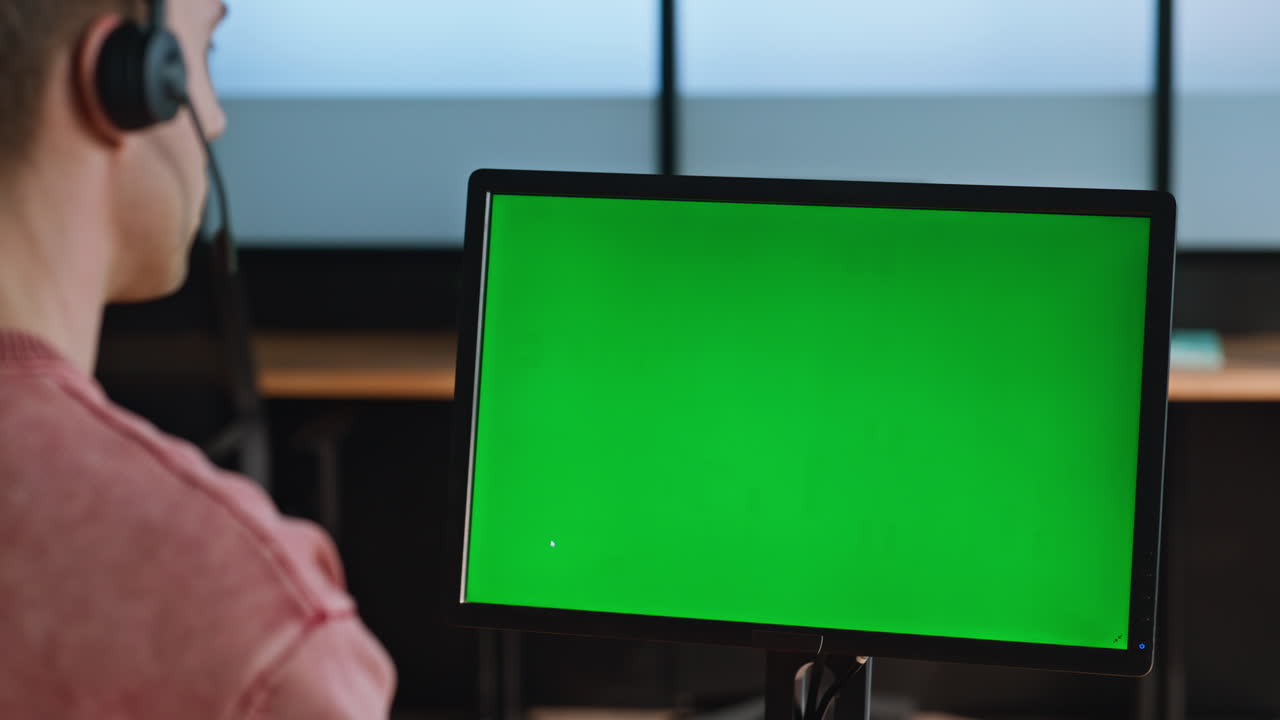 Corporate manager looking greenscreen talking headset at light workplace closeup