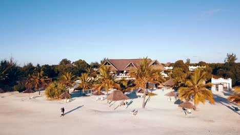 Increíble-Hacia-Atrás-Se-Eleva-Lentamente-Disparado-Por-Un-Dron-Al-Atardecer-Largas-Sombras-Desde-Una-Villa-De-Lujo-Hasta-Un-Dron-Disparado-En-El-Mar-En-Zanzíbar-En-áfrica-En-Invierno-De-2019