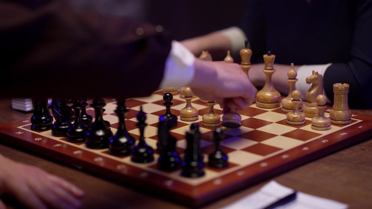 Gros plan sur des joueurs d'échecs effectuant des coups et notant la partie
