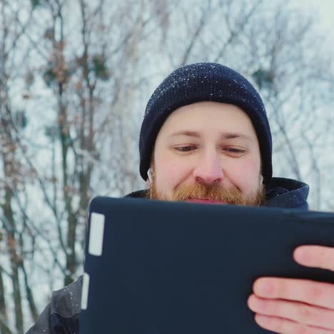 Smiling-Man-Uses-Tablet-In-Winter-Park-02