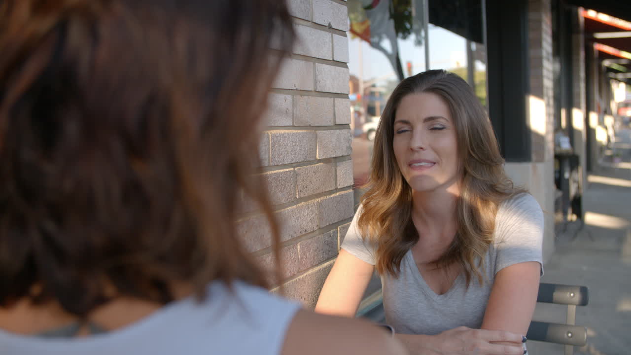 Two female friends talking outside a coffee shop