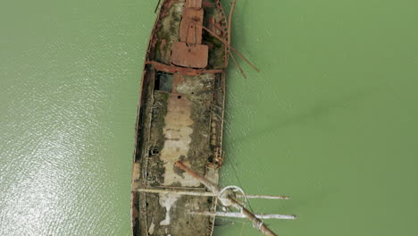 Rostiges-Rotes-Schiffswrack-Steckte-Im-Seichten-Grünen-Wasser-Fest