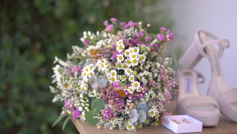 extreme close-up shot of wildflowers bouquet with bride accessories, camera floating