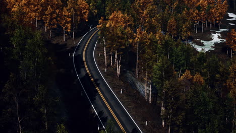 Aerial-over-a-winding-forest-road-in-Finland-during-sunset